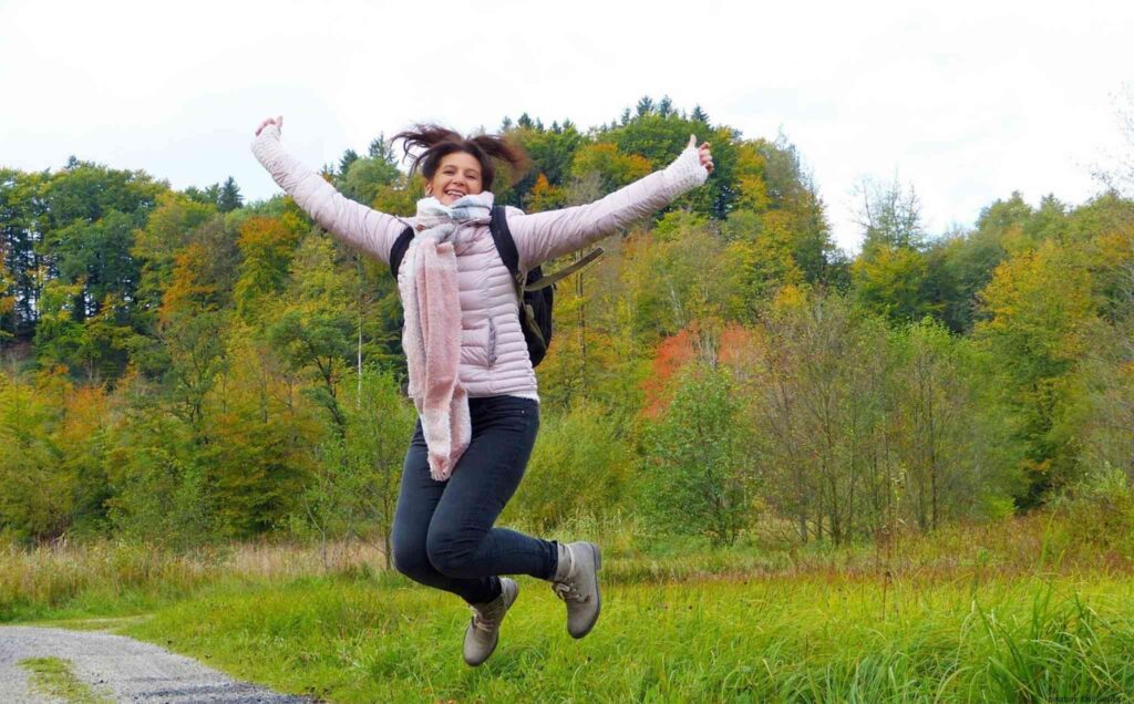 Frau beim Spazierengehen, die in die Luft spingt