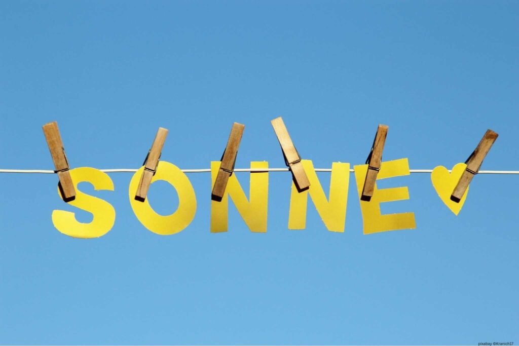 Auf einer Wäscheleine gelbe Buchstaben, die das Wort SONNE ergeben