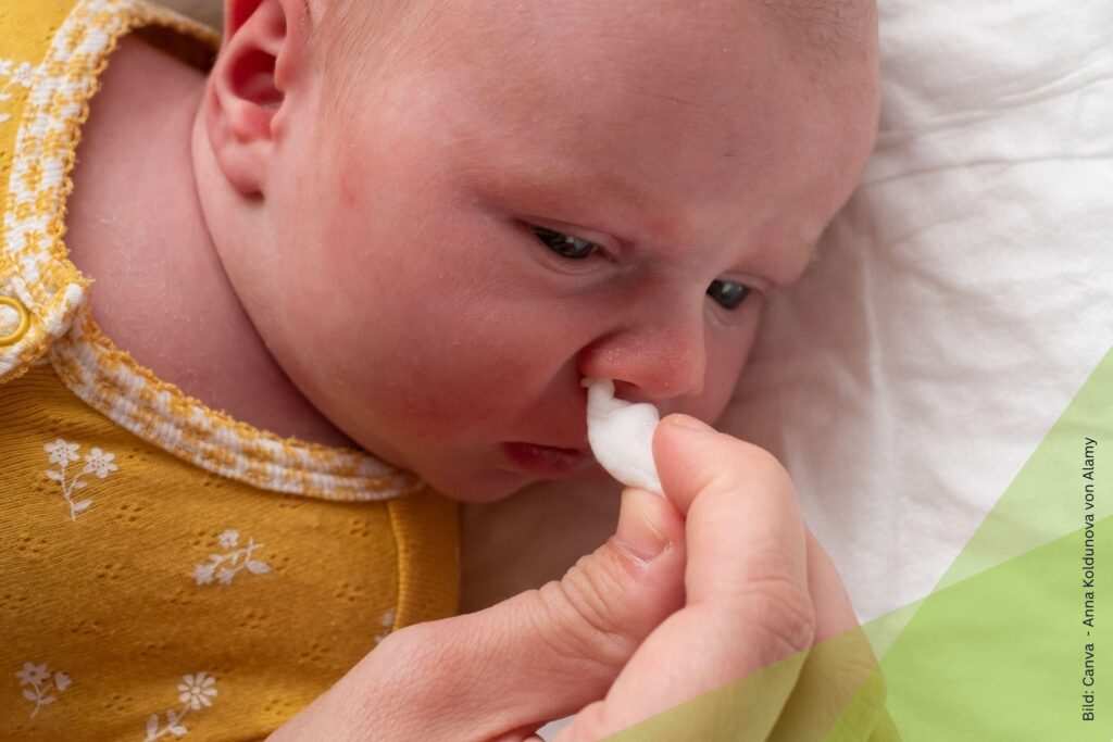Baby mit Erkältung wird die Nase geputzt zum Thema Erkältung beim Baby: Homöopathie bei Schnupfen, Husten und Unruhe